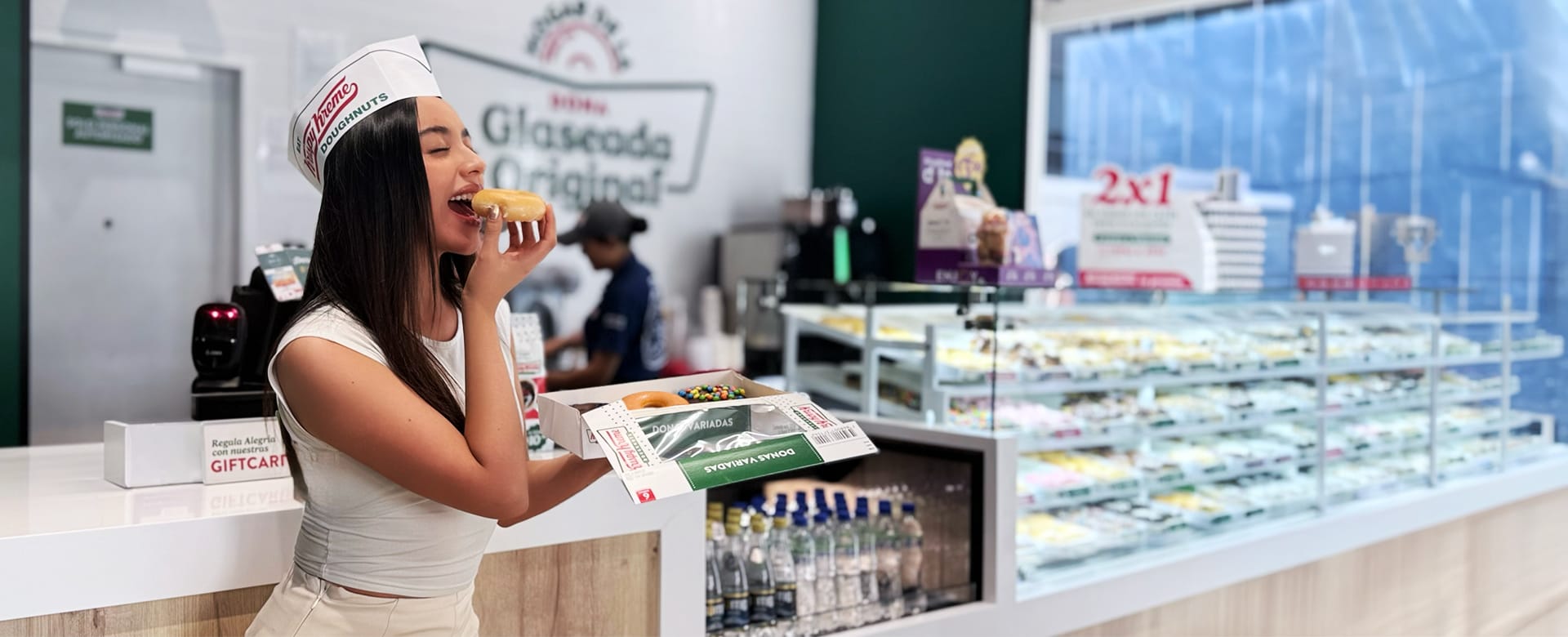 Clienta disfrutando una docena de donas Krispy Kreme en una tienda de Ecuador